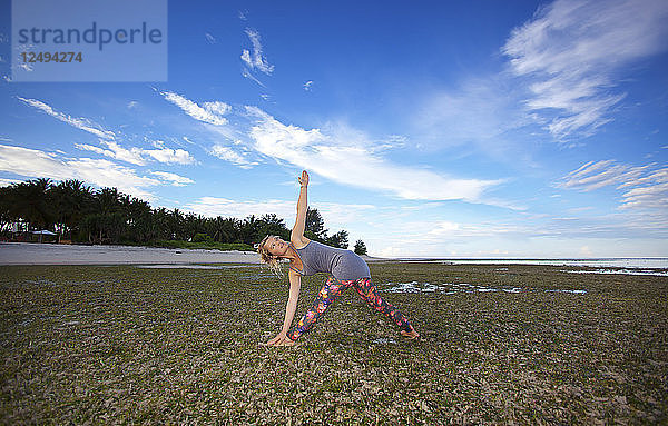 Schönes Mädchen am Strand macht Yoga. Indonesien Gili Insel