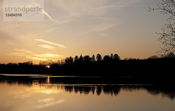 Sonnenuntergang über einem stillen See im Vereinigten Königreich