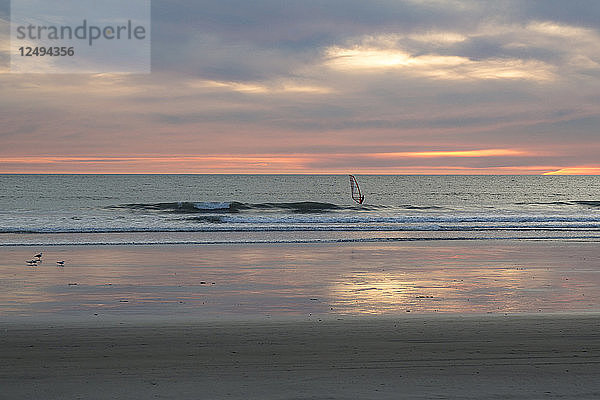 Windsurfer nimmt eine letzte Welle bei Sonnenuntergang in Oceanside  Kalifornien