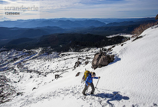 Ein Bergsteiger bewegt sich durch den Schnee bergauf  während er versucht  den Mt. St. Helens in Washington zu besteigen.