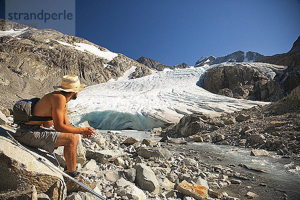 Ein Wanderer blickt auf den Wedge Glacier  der in der Mittagssonne im Garibaldi Provincial Park schmilzt.