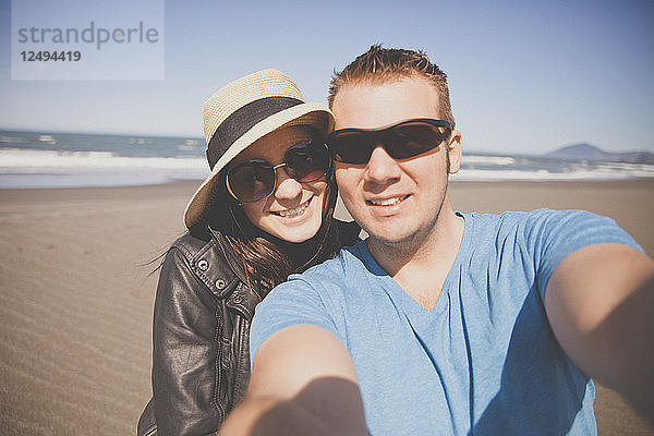Ein Paar macht ein Selfie im Urlaub an der Küste von Oregon.