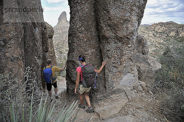 Ein Mann und eine Frau erkunden die Felsformationen am Fremont Saddle auf dem beliebten Peralta Trail in der Superstition Wilderness Area  Tonto National Forest in der Nähe von Phoenix  Arizona  November 2011. Der Weg bietet spektakuläre Ausblicke auf Weavers Needle und die raue Sonoran-Wüste.