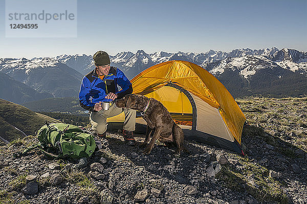 Ein Mann mit einer Tasse Tee und sein Hund Camping auf einer Ridgeline über Molas Pass in Durango  Colorado
