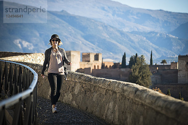 Ein Mädchen geht an einem sonnigen Tag einen Weg in der Nähe der Alhambra in Granada  Spanien  entlang.