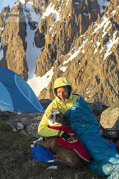 Eine Frau und ihr Hund zelten auf dem Blaine Peak unterhalb des Mount Sneffels