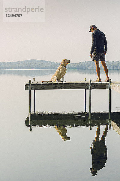 Mann mit seinem Hund am Rande eines Docks am Kaspischen See