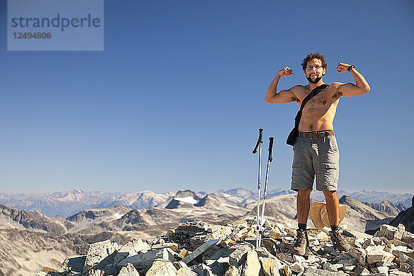 Ein Wanderer ohne Hemd lässt seine Muskeln spielen  nachdem er den Gipfel des Mount Cook im Garibaldi Provincial Park erreicht hat.
