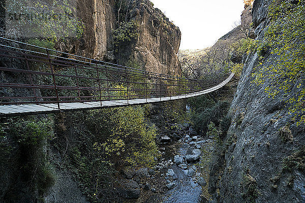 Eine Hängebrücke hängt in einer Schlucht in den Bergen Spaniens.