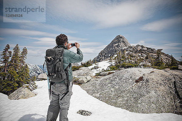 Ein Rucksacktourist fotografiert den Needle Peak kurz vor Erreichen des Gipfels.