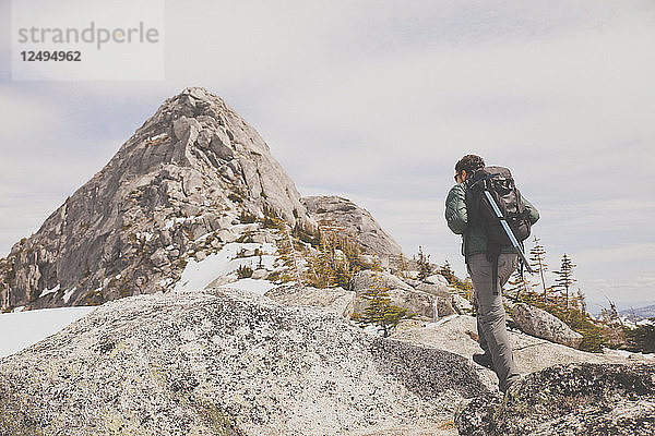 Ein Rucksacktourist wandert über Grantie zum Gipfel des Needle Peak  BC  Kanada.
