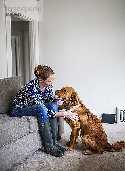 Eine junge Hundebesitzerin genießt die Zeit mit ihrem Hund in ihrem Haus.