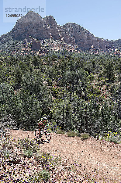 Eine Frau reitet auf dem beliebten Bell Rock Pathway in der Nähe von Courthouse Butte in South Sedona  Arizona. Der Bell Rock Pathway ist ein beliebter Ausgangspunkt für die klassischen Rundwanderwege in Sedona.