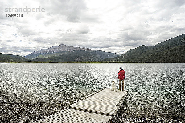 Muncho Lake British Columbia Mann und Hund auf dem Steg