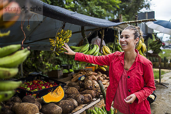 Junge Frau auf einem Obstmarkt am Straßenrand in Puerto Rico