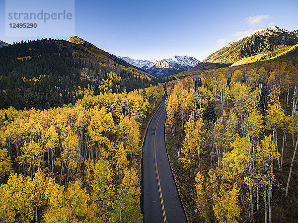 Luftaufnahme der Herbstfarben und einer Straße in Aspen Colorado mit frischem Schneefall