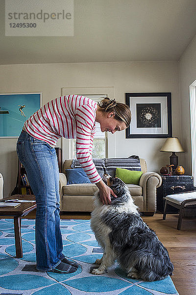 Ein junger Hundebesitzer genießt die Zeit mit seinem Hund in seinem Haus.