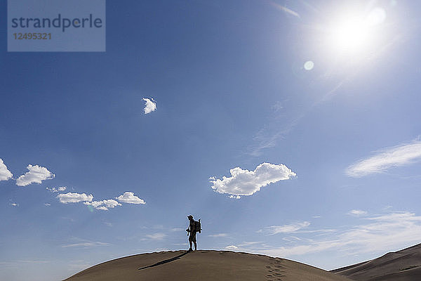 Ein Wanderer auf einer Kammlinie in den Sanddünen