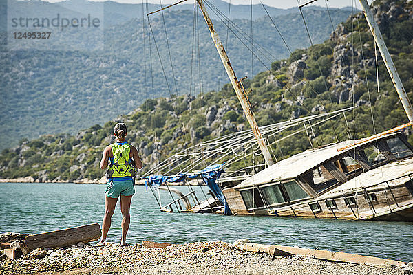 Ein Mädchen blickt auf ein sinkendes Schiff vor der türkischen Küste.