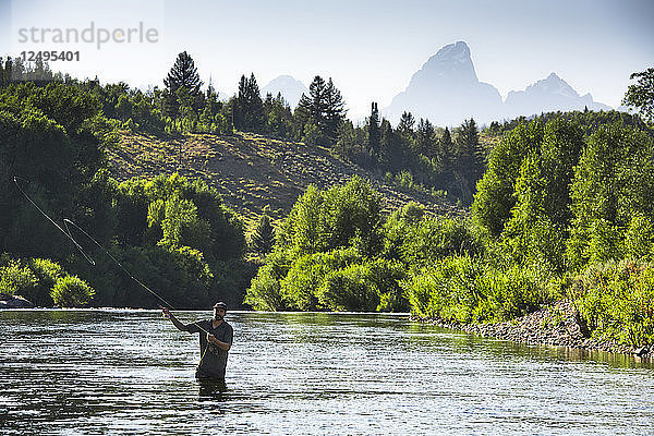 Ein Fliegenfischer im Gros Ventre River mit Grand Teton Mountains im Hintergrund  Jackson Hole  Wyoming