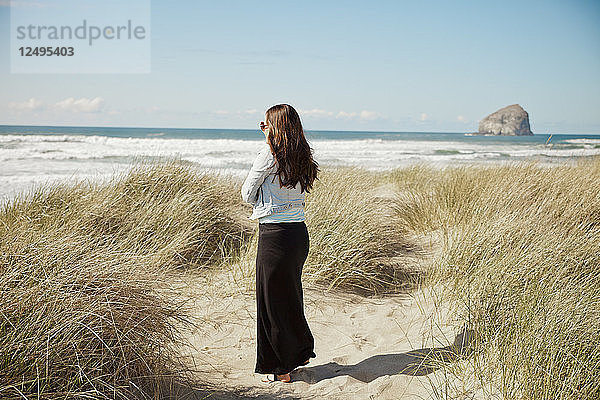 Eine Frau genießt den Strand und die Aussicht in der Nähe von Pacific City  Oregon.