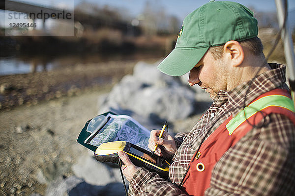 Ein Außendiensttechniker sammelt Daten mit einem GPS-Gerät in Vancouver  B.C.