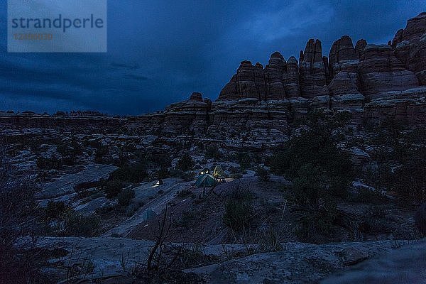 Beleuchteter Zeltplatz über einer Felsformation im Canyonlands National Park