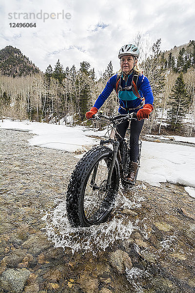 Eine Frau fährt mit ihrem Fat-Ready-Bike über einen Bach im La Plata Canyon  Mayday  Colorado.