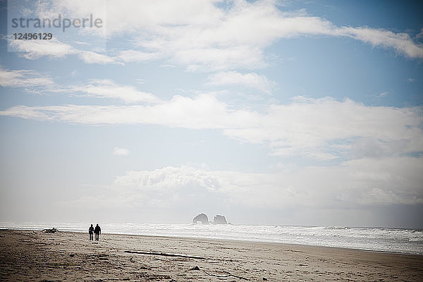 Ein Paar spaziert in der Nähe von Twin Rocks am Rockaway Beach  Oregon.