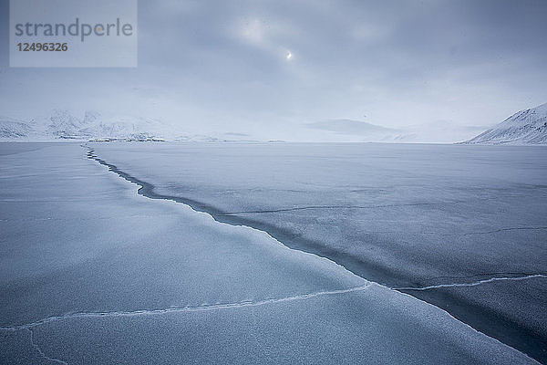 Ein Einschnitt im Packeis führt zu verschneiten Bergen im Hintergrund in Spitzbergen  Svalbard