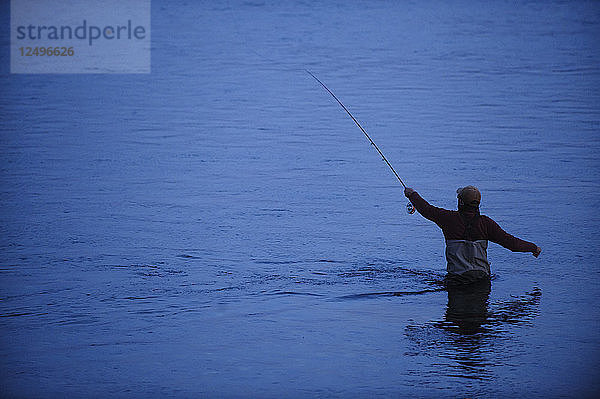 Angler beim Werfen in der Abenddämmerung an einem Fluss in Patagonien  Argentinien.