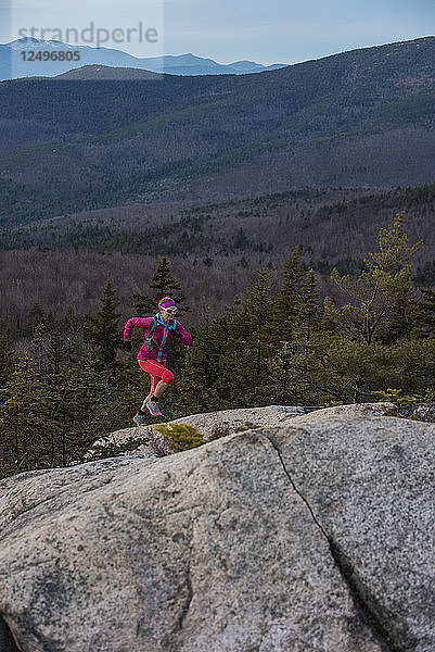 Trailrunnerin Kristina Folcik läuft die steile Granitplatte mit dem Mount Washington in der Ferne hinauf.