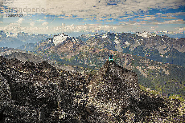 Lange Belichtung von weiblichen Bergsteiger sitzt auf dem Gipfel des Mount Marriott