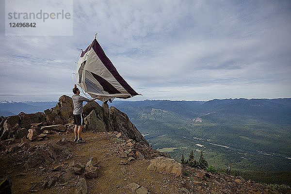 Ein Wanderer schüttelt sein Zelt aus  nachdem er auf dem Gipfel des Sauk Mountain  Washington  gezeltet hat.