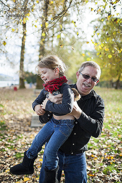 Großvater spielt mit seiner Enkelin im Park