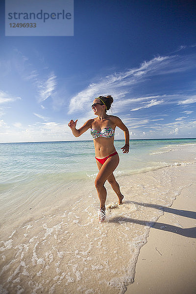 Eine junge attraktive Frau läuft am Strand von Cayo Coco  Kuba.
