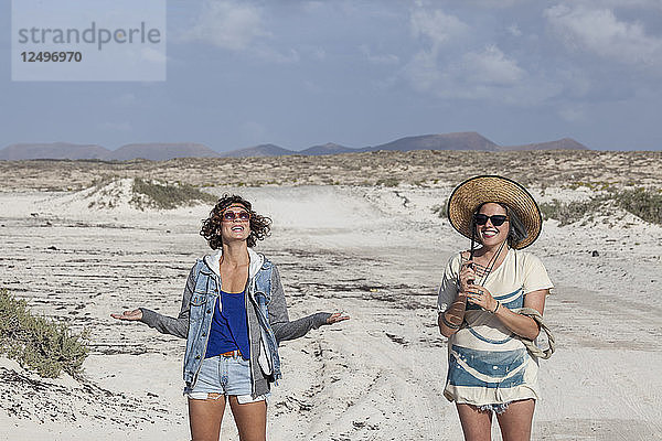 Zwei Mädchen  die mitten in der Wüste Spaß haben  Fuerteventura  Kanarische Inseln