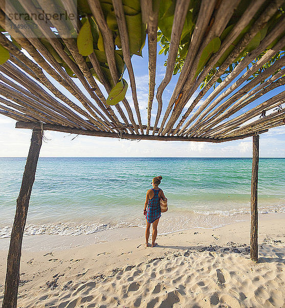 Eine junge Frau trägt eine Strandtasche am Strand von Cayo Coco  Kuba.