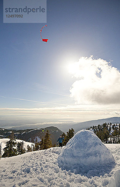 Ein Wanderer lässt einen Drachen über seinem Iglu auf dem Gipfel des Seymour Mountain  Kanada  steigen
