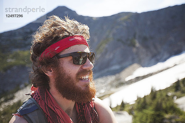 Porträt von Evan Howard  einem Bergsteiger und Entdecker  der ein Kopftuch trägt und einen dichten Bart hat.