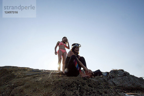 Zwei Frauen entspannen sich auf dem Felsen der Petit Perello Cove