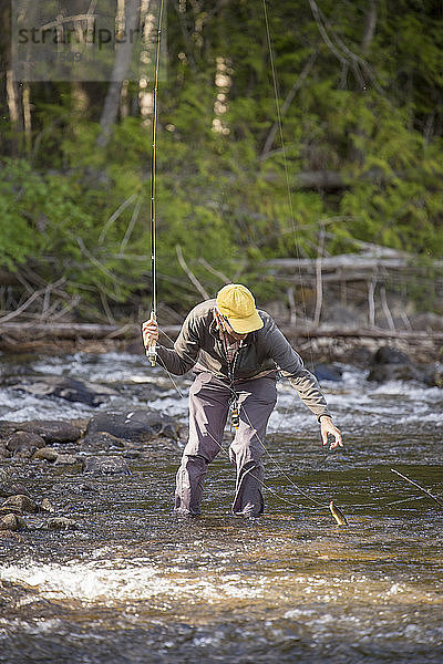 Mann fängt Rotbandforelle beim Fliegenfischen am Yaak River in Montana