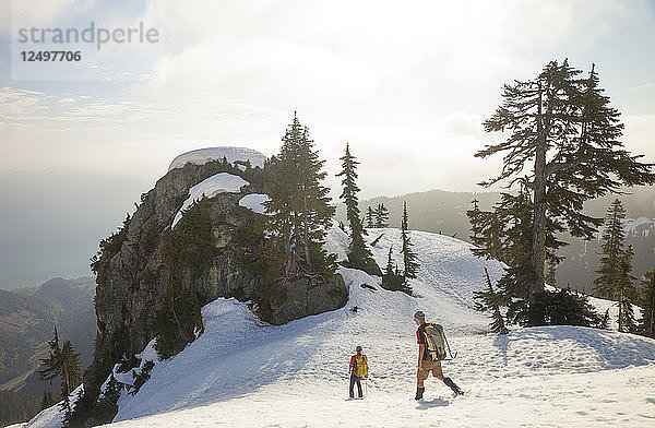 Zwei Bergsteiger steigen nach einem Ausflug in die Berge von British Columbia  Kanada  von einem Schneefeld ab.