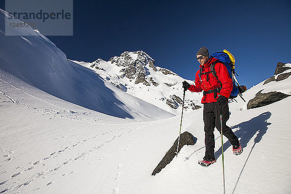 Zwei Rucksacktouristen wandern durch eine schneebedeckte Landschaft unterhalb des Joffre Peak  British Columbia  Kanada.