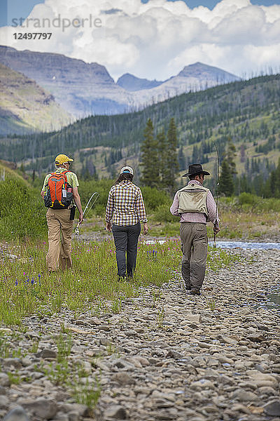 Zwei Männer und eine Frau gehen entlang des Mountain River nördlich des Yellowstone National Park