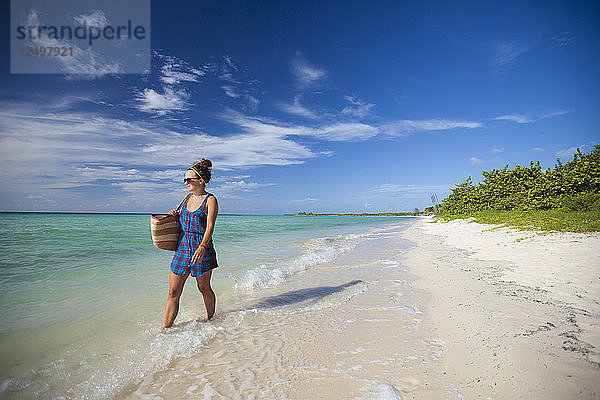 Eine junge Frau spaziert an einem Strand in Cayo Coco  Kuba  entlang.