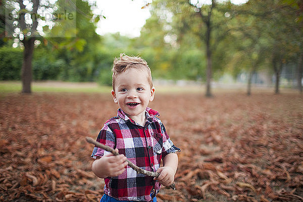 Porträt eines kleinen Jungen  der im Park spielt