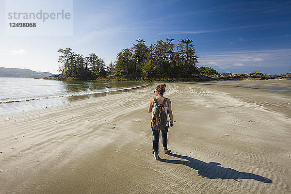 Eine junge Frau geht am Chesterman Beach in Tofino  British Columbia  Kanada  in Richtung Frank Island.