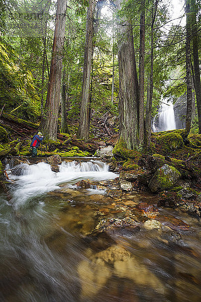 Ein Fotograf macht ein Foto von den Cedar Hollow Falls im North Cascades National Park  Washington.