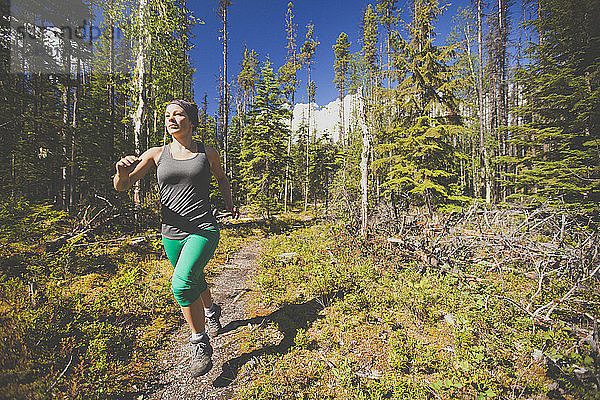 Eine aktive Frau beim Trailrunning im Bowron Lake Provincial Park.